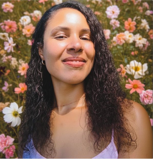 Naudia, transformation coach and creator of Bloom, photographed among wildflowers